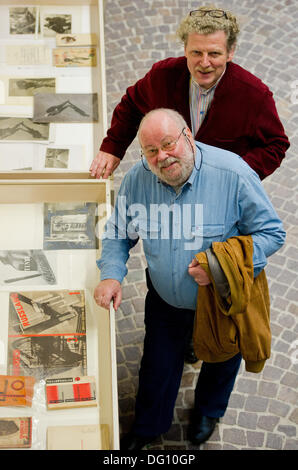 Hannover, Germania. Undicesimo oct, 2013. Jen Lissitzky (anteriore) e direttore del museo, Ulrich Krempel a piedi passato foto da Jen Lissitzky i genitori di El Lissitzky e Sophie Lissitzky-Krueppers presso il Museo Sprengel di Hannover, Germania, 11 ottobre 2013. Il patrimonio privato delle avanguardie russe artista El Lissitzky e sua moglie Sophie Lissitzky-Kueppers sarà presentato al Sprengel Museum di Hannover. Foto: Christoph Schmidt/dpa/Alamy Live News Foto Stock