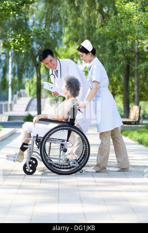 Medico, Infermiere e sedia a rotelle paziente legato Foto Stock