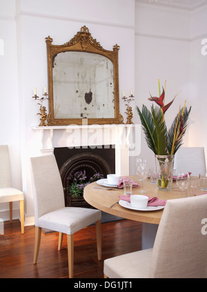 Antico specchio dorato bianco sopra caminetto in soggiorno con nero+a  strisce bianche sedie imbottite Foto stock - Alamy