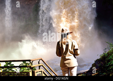 Argentina, Iguassu National Park: Femmina per turisti in cerca di collegare in cascata del Iguassu Falls dal circuito superiore Foto Stock