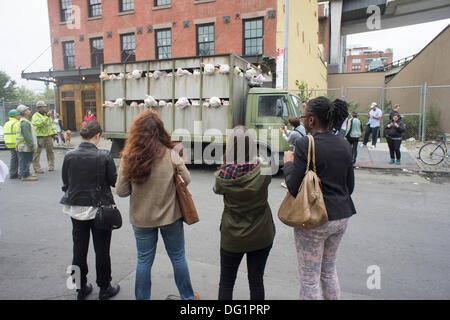 New York City, NY, STATI UNITI D'AMERICA . Undicesimo oct, 2013. Gli appassionati di Banksy gregge del quartiere alla moda di Meatpacking District di New York su Venerdì, Ottobre 11, 2013 per vedere l'undicesima puntata di Banksy arte, "Le Sirene degli agnelli". Questo particolare pezzo scultoreo consiste in un macello carrello riempito con belati animali di peluche, controllata da burattinai, che furono condotti in giro da un conducente che è rimasto nel carattere. Credito: Richard Levine/Alamy Live News Foto Stock