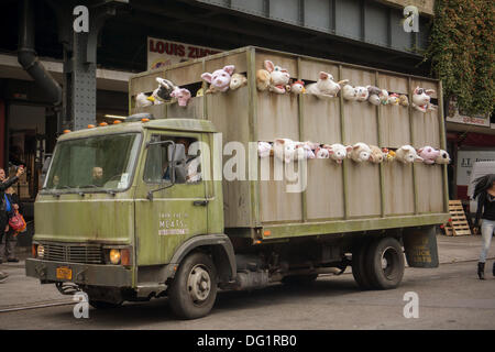 New York City, NY, STATI UNITI D'AMERICA. Undicesimo oct, 2013. Gli appassionati di Banksy gregge del quartiere alla moda di Meatpacking District di New York su Venerdì, Ottobre 11, 2013 per vedere l'undicesima puntata di Banksy arte, "Le Sirene degli agnelli". Questo particolare pezzo scultoreo consiste in un macello carrello riempito con belati animali di peluche, controllata da burattinai, che furono condotti in giro da un conducente che è rimasto nel carattere. Credito: Francesca Roberts/Alamy Live News Foto Stock