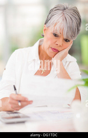 Ha sottolineato la donna senior di pagare le bollette di lei Foto Stock