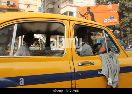 Ambasciatore giallo taxi auto passa attraverso la strada indiano il Nov 30, 2012 in Kolkata, India. Foto Stock