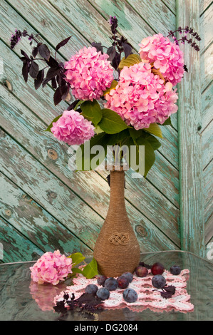 Ortensie rosa e viola bouquet di basilico in un vaso vintage still life Foto Stock