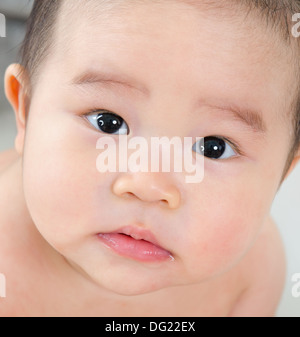 Close up volto di sei mesi Asian baby boy con sguardo curioso Foto Stock