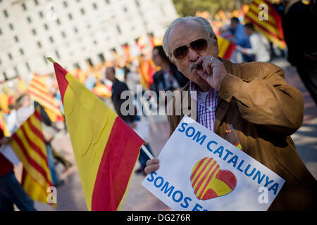 Barcellona, Spagna. Xii Ottobre 2013. Un uomo che porta una bandiera spagnola in Plaza Catalunya a Barcellona. Giornata Ispanica è segnato dalla crisi stalking la Spagna e la crescente richiesta di indipendenza dalla popolazione catalana. Alcune migliaia di persone hanno manifestato per l'unione del territorio spagnolo. Credito: Jordi Boixareu/Alamy Live News Foto Stock