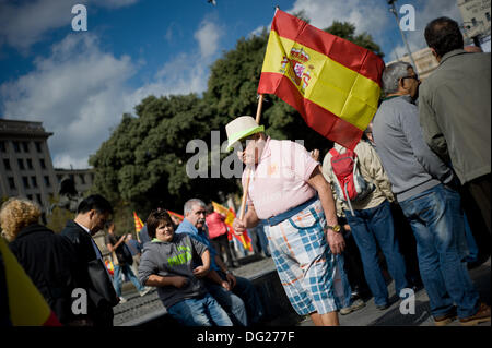 Barcellona, Spagna. Xii Ottobre 2013. Un uomo che porta una bandiera spagnola in Plaza Catalunya a Barcellona. Giornata Ispanica è segnato dalla crisi stalking la Spagna e la crescente richiesta di indipendenza dalla popolazione catalana. Alcune migliaia di persone hanno manifestato per l'unione del territorio spagnolo. Credito: Jordi Boixareu/Alamy Live News Foto Stock