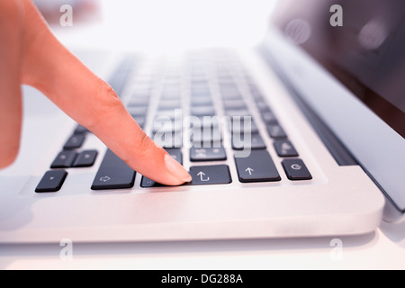 Donna dito laptop desk interni Foto Stock