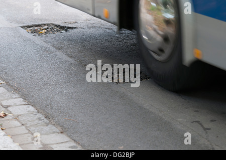 Asfalto di fori sul fondo stradale. Auto in un moto Foto Stock