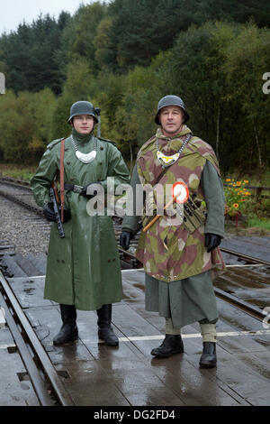 1940 Tempo di guerra esercito tedesco gli uomini a Levisham. North Yorkshire, Regno Unito. 11 ottobre, 2013. Feld Gendarme al "ferrovia in tempo di guerra' Nord nello Yorkshire Moors Railway (NYMR) evento a Levisham stazione ferroviaria in condizioni di tempo inclemente sul weekend 12 -13 ottobre 2013. Stazione Levisham era decorato con periodo di poster e insegne francesi durante il (NYMR) "Weekend di guerra" di diventare 'Le Visham' nel nord della Francia. La raccolta, una ricreazione di un villaggio francese occupato dalla Seconda Guerra Mondiale, la II Guerra Mondiale, seconda guerra mondiale, durante la seconda guerra mondiale, WW2 truppe tedesche. Foto Stock