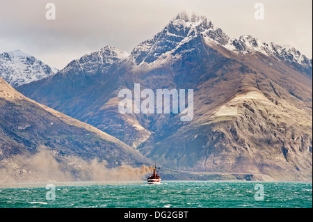 Queenstown, South Island, in Nuova Zelanda. Il sistema di cottura a vapore di piacere TSS Earnslaw sul lago Wakatipu, contro uno sfondo di montagne Foto Stock