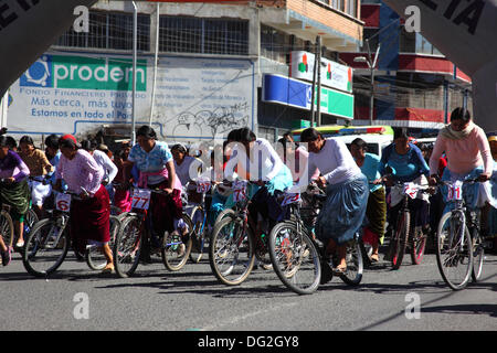 El alto, Bolivia. 12 ottobre 2013. Le concorrenti avviano una corsa di biciclette Cholitas per donne indigene Aymara. La gara si svolge ad un'altitudine di poco più di 4.000 m lungo le strade principali della città di El alto (sopra la Paz) per il Womens Day boliviano, che si è svolto ieri venerdì 11 ottobre. Crediti: James Brunker / Alamy Live News Foto Stock