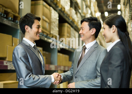 La gente di affari si stringono la mano in magazzino Foto Stock