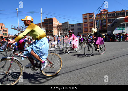 El Alto in Bolivia. Xii oct, 2013. Un concorrente giostre spectactors del passato come lei prende parte a una bicicletta Cholitas gara per gli indigeni Aymara donne. La gara si terrà ad una altitudine di poco più di 4.000 m lungo le strade principali della città di El Alto (sopra la capitale La Paz) per boliviano Giornata della donna che era ieri Venerdì 11 ottobre. Credito: James Brunker / Alamy Live News Foto Stock