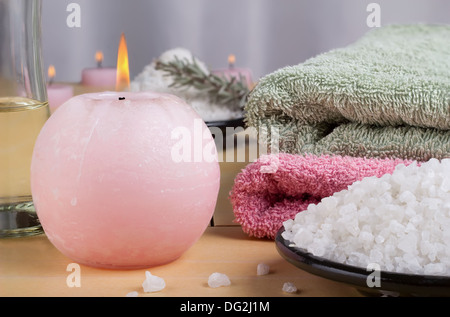 Centro termale aromatico impostato con sale marino e candele colorate. Foto Stock