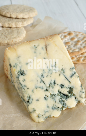 Del formaggio Stilton su di età compresa la carta pergamena con oat biscotti e cracker. Foto Stock
