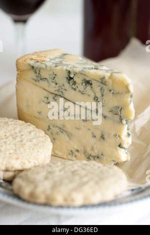 Del formaggio Stilton su di età compresa la carta pergamena con biscotti di avena. Messa a fuoco selettiva sulle vene più grandi Foto Stock