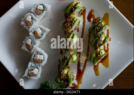 Rotoli di Avocado e sushi su piastra ad alto angolo di visione Foto Stock