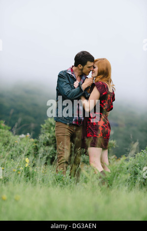 Coppia romantica circa al bacio nel campo di nebbia Foto Stock