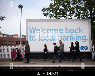 Trustee Savings Bank advert tsb poster palizzata, a Londra la stazione ferroviaria con i pendolari a piedi passato Foto Stock