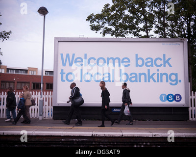 Trustee Savings Bank advert tsb poster palizzata, a Londra la stazione ferroviaria con i pendolari a piedi passato Foto Stock