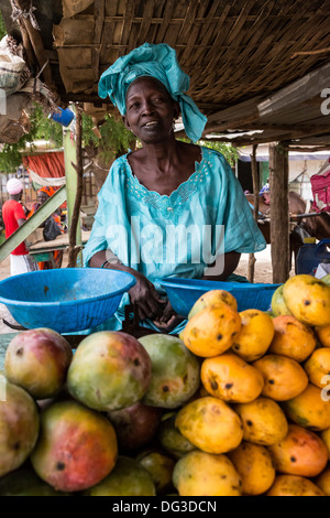 Il Senegal, Touba. Donna vendita di manghi presso la stazione degli autobus. Foto Stock