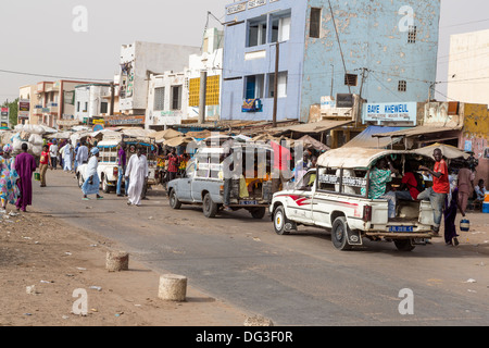 Il Senegal, Touba. Il trasporto locale. Pick-up con i giovani uomini di solito appeso sul retro della scheda In esecuzione, passeggeri all'interno. Foto Stock