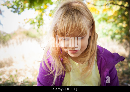 Ritratto di poco sorridente ragazza bionda in autunno park Foto Stock