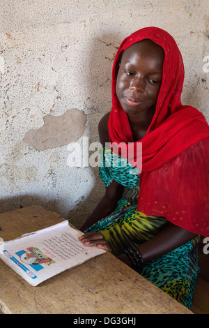 Il Senegal, Touba. Giovane ragazza a Al-Azhar madrasa, una scuola di studi islamici. Il suo libro mostra che ella è imparare l'Arabo. Foto Stock