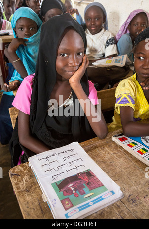 Il Senegal, Touba. Ragazza giovane con il suo lettore di arabo a Al-Azhar madrasa, una scuola di studi islamici. Foto Stock