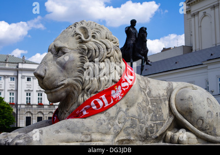 La scultura in pietra di un leone di fronte al Palazzo Presidenziale a Varsavia in Polonia con una sciarpa calcio sostenendo la Polonia Foto Stock