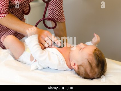 Gli esami medico di neonati con uno stetoscopio in una clinica Foto Stock