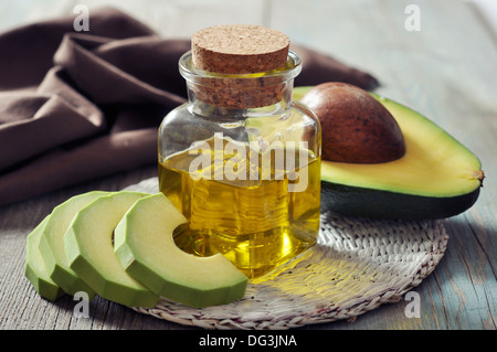 Bottiglia di avocado olio essenziale con fresca frutta avocado closeup Foto Stock