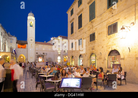La torre dell Orologio e ristoranti al crepuscolo, Stradun, Sito Patrimonio Mondiale dell'UNESCO, Dubrovnik, costa dalmata, Dalmazia, Croazia, Europa Foto Stock
