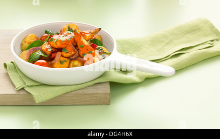 Piri Piri pollo con patate di primizia, spinaci, pomodori e cipolla rossa Foto Stock