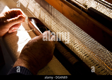 Tessitura tradizionale in Eddie Doherty il tweed workshop a Ardara County Donegal Irlanda. Qui Eddie thread una navetta Foto Stock