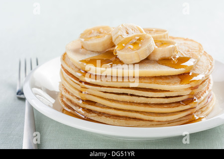 Frittelle di banane e di sciroppo sulla piastra bianca Foto Stock