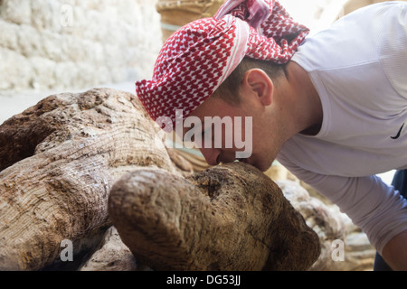 Lalish, yazidi città santa nel nord Iraq - Un uomo che grattano il tronco santo per evitare incubi Foto Stock