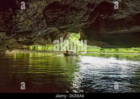 Viaggia attraverso una grotta sul Tam Coc fiume di Ninh Binh, Vietnam Foto Stock