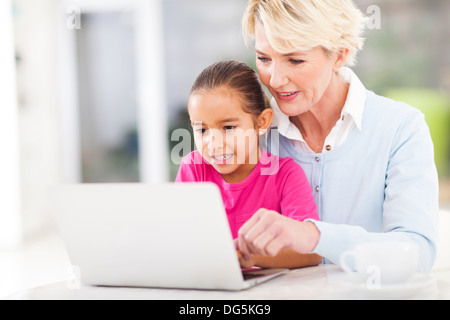 Nonna moderna insegnamento nipote come utilizzare il computer portatile a casa Foto Stock