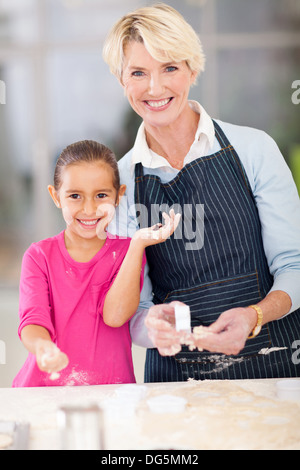 Ritratto di bambina e la nonna senior la cottura a casa Foto Stock
