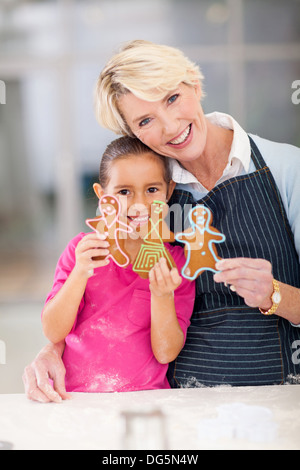 Felice donna senior e nipote holding gingerbread cookies hanno appena cotti Foto Stock