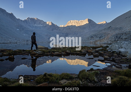 Un uomo che guarda la montagna vista la mattina sulla neve Lago e Monte Mulini nelle montagne della Sierra Nevada Foto Stock