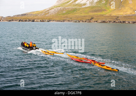 I passeggeri e il kayak da mare in un Zodiak off il russo nave di ricerca, AkademiK Sergey Vavilov un rafforzamento di ghiaccio nave per una crociera spedizione al nord Svalbard. Foto Stock