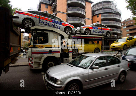 Il 15 ottobre 2013. Londra REGNO UNITO. Due auto della polizia sono trasportati sulla parte superiore di un carrello nel centro di Londra Foto Stock