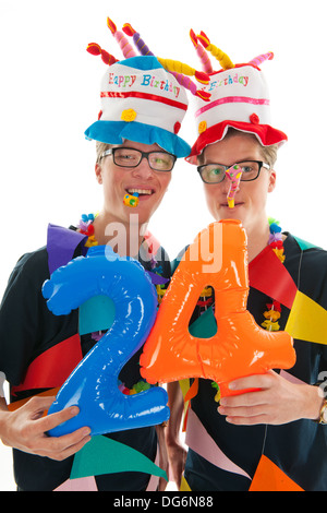 Identicamente maschio adulto gemelli avente il compleanno in studio Foto Stock