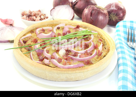 Onion tart con porri e pancetta affumicata su uno sfondo luminoso Foto Stock
