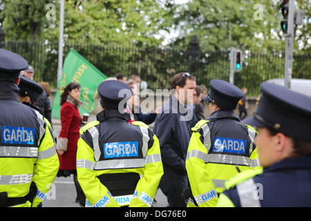 Dublino, Irlanda. Il 15 ottobre 2013. Garda ufficiali (funzionari di polizia) blocco manifestanti dal repubblicano irlandese del Gruppo Vocale accesso a Kildare Street vicino al Dail (parlamento irlandese). Numerose proteste sono state andando su nel centro di Dublino il giorno il ministro delle Finanze Michael Noonan si appresta a presentare il bilancio per il 2014. Essi protesta contro l'aumento delle tasse e i tagli nella spesa pubblica. Foto Stock