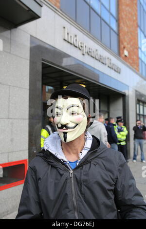 Dublino, Irlanda. Il 15 ottobre 2013. Un manifestante indossa una maschera di Guy Fawkes al di fuori della casa indipendente, sede di Independent News & Media. Numerose proteste sono state andando su nel centro di Dublino il giorno il ministro delle Finanze Michael Noonan si appresta a presentare il bilancio per il 2014. Essi protesta contro l'aumento delle tasse e i tagli nella spesa pubblica. Foto Stock